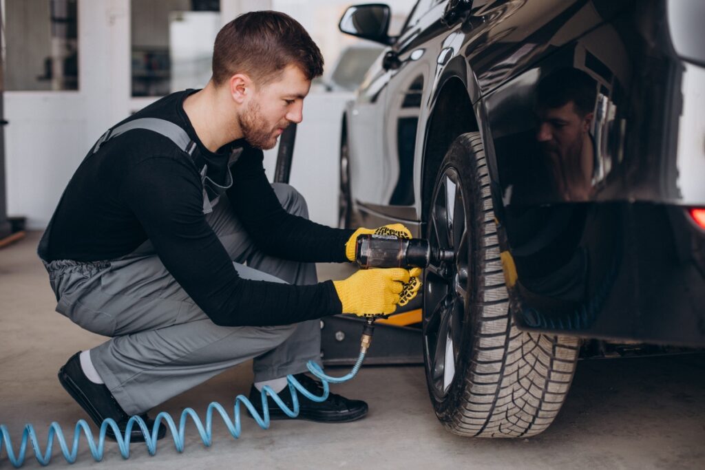 A mechanic inspecting tires on a vehicle